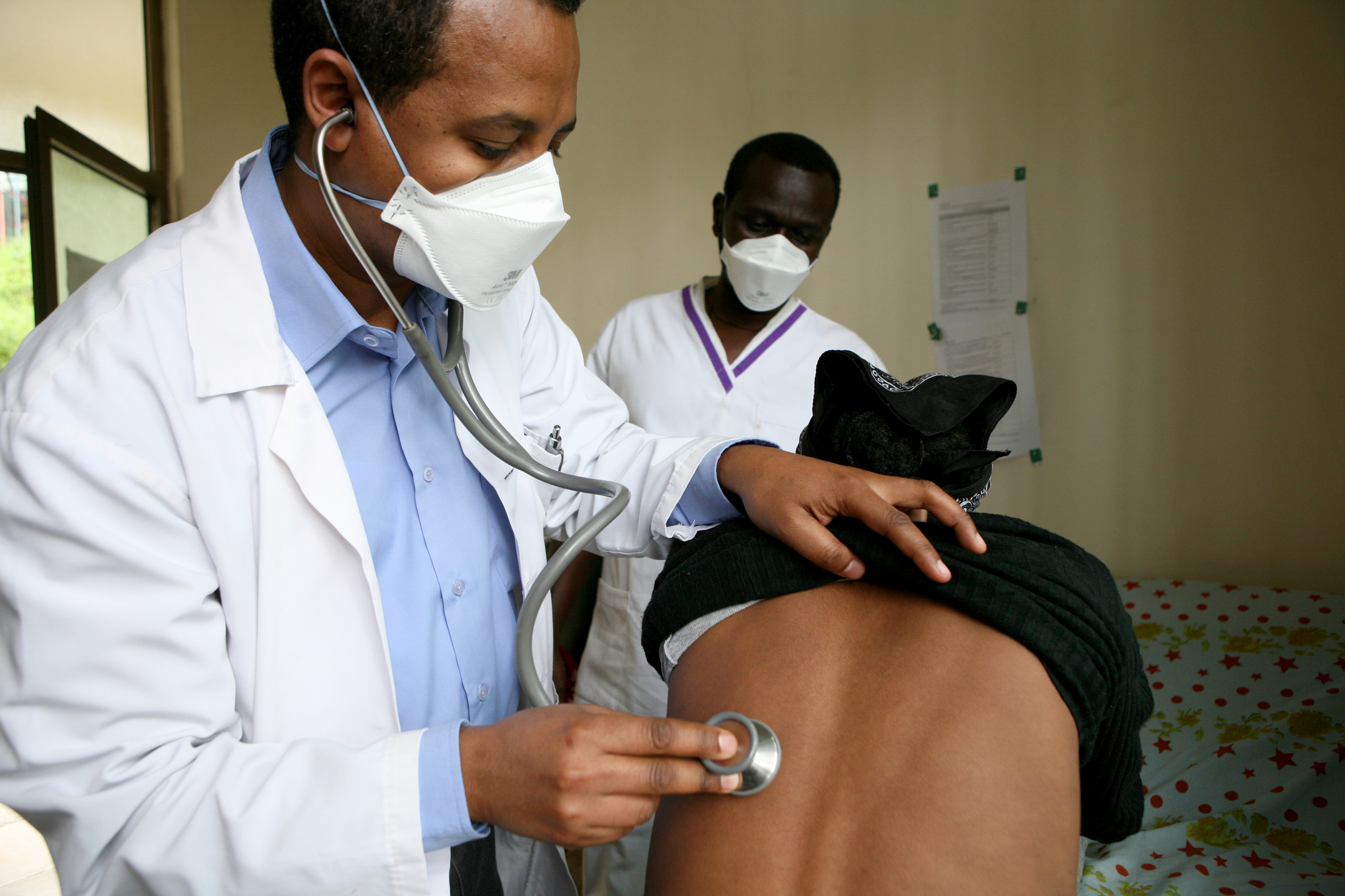 A health professional examines a patient